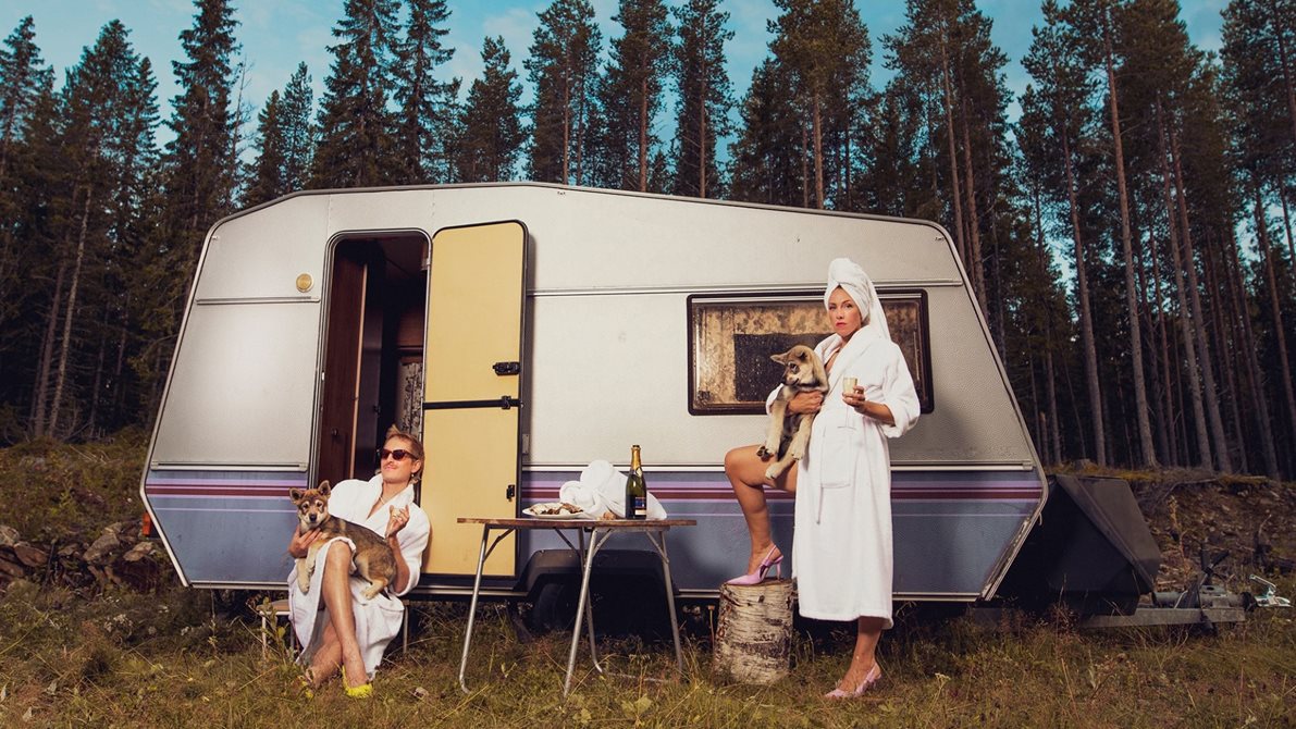 People in fornt of a camping wagon